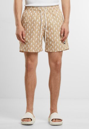 Kurze beige Badeshorts mit einem weißen Seepferdchen-Muster. Verfügt über einen elastischen Bund mit Kordelzug und einem kleinen Logoetikett.