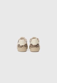 Vista posteriore di sneakers beige con dettagli a stampa leopardata, suola testurizzata e tallone e linguetta color crema. Visibili sottili dettagli di cucitura.