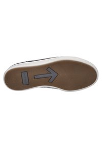 Sicht auf die Schuhsohle mit einer strukturierten, braunen Gummibasis, einem weißen Rand und einem Pfeilmuster in Grau auf der Oberfläche.