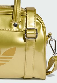Metallic yellow handbag with smooth surface, dual handles, adjustable strap, silver hardware, and embossed logo detail.