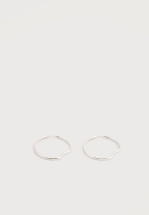 Két egyszerű, vékony ezüstkarika fülbevaló finom ívelt részlettel, fehér háttéren.
