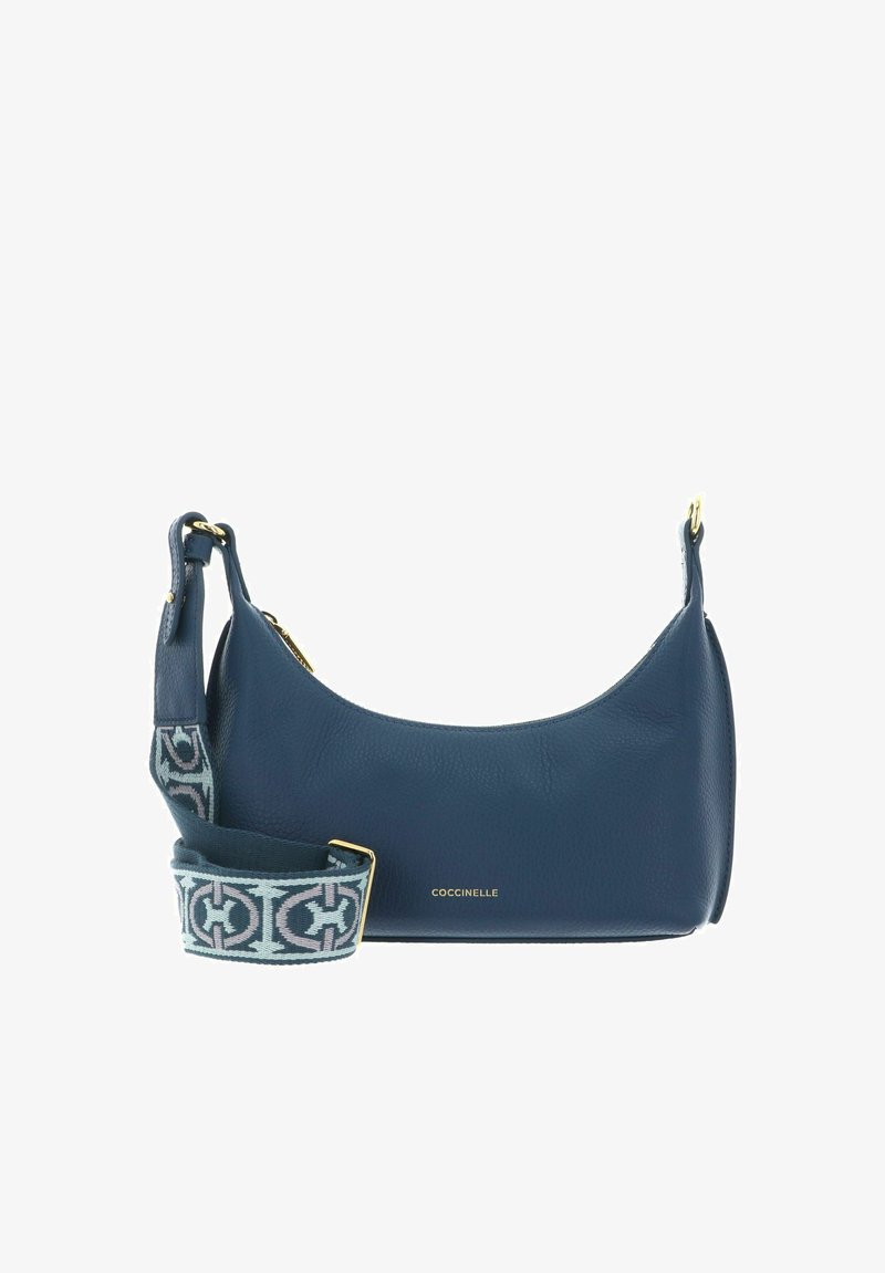 Sac à bandoulière en cuir bleu avec fermeture éclair dorée et sangle amovible à motifs, avec un petit logo doré "Coccinelle" sur le devant.