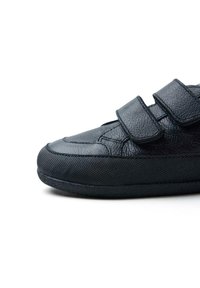 Sneaker nera con tomaia in pelle texturizzata, due cinturini in velcro e suola in gomma, caratterizzata da un profilo basso e una punta arrotondata.