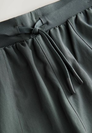 Dark gray elastic waistband shorts with a drawstring, featuring soft fabric, smooth texture, and visible stitching details.