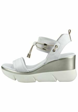 Witte sleehak sandaal met zilverkleurige platformzool, verstelbare elastische enkelband met trekkoord, en open teen ontwerp.