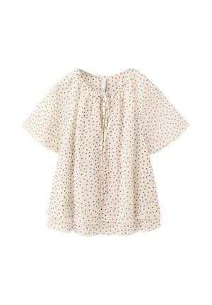 Blusa crema de manga corta con lunares negros, escote redondo y detalle de lazo delantero, corte holgado, tela ligera.