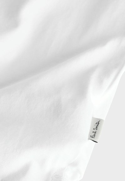 Bijela pamučna tkanina s glatkom teksturom, s malom oznakom s brandom "Paul Smith" u crnom tekstu. Suptilan dijagonalni uzorak tkanja.