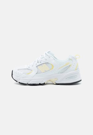 Hvid New Balance 530 sneaker med mesh-paneler, cremefarvede accenter og sort gummisål vist på en hvid baggrund.
