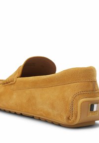 Suede loafers i en sennepsgul farve med en afrundet form, dekorativ syning og en mærket gummisål med hæl-akkent.