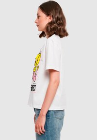 Valge puuvillane T-särk, millel on värvikas koomiksigraafika kollasest linnust roosa keelega, tekst all, lühikesed varrukad, mugav lõige.