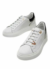 Zapatillas de cuero blanco con acentos en el talón negros, que presentan cordones grises, ojales dorados y una suela de goma texturizada. Diseño minimalista.
