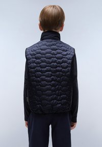 Svart vadderad väst med hög krage, tillverkad av ett slätt, glansigt material. Har en texturerad design och en figurnära silhuett.