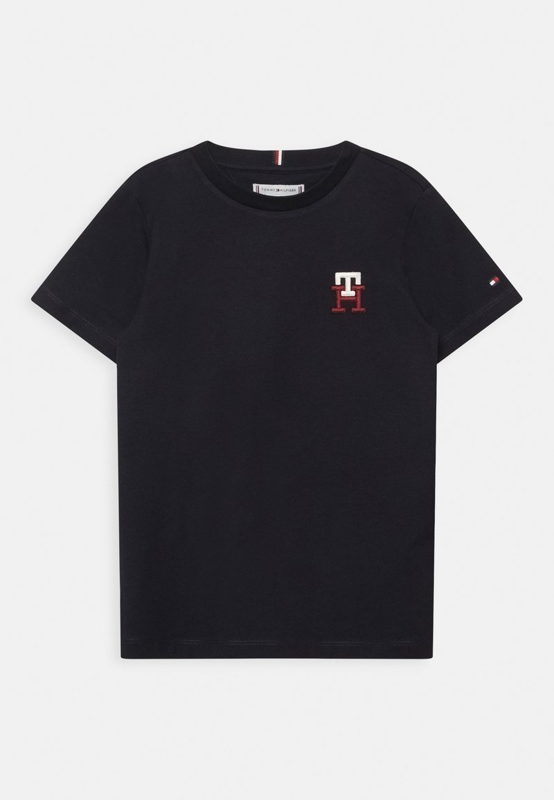 Black short-sleeve crew neck t-shirt with small red and white "TH" logo on left chest and tiny flag logo on left sleeve.