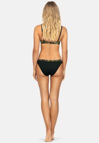 Czarny zestaw bikini z wzorzystym paskiem. Górna część ma cienkie ramiączka, a dół ma niską talię z dopasowanymi detalami.