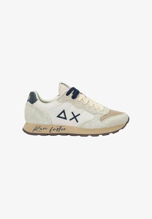 Sneakers met een beige en crème bovenkant, gemaakt van suède en mesh materialen, donkerblauwe veters en zwarte accenten; "Loop sneller" gedrukt op de zool.
