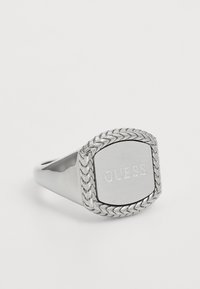 Silver ring with a square top featuring an engraved "GUESS" logo. Braided texture accents the edges, polished smooth band.