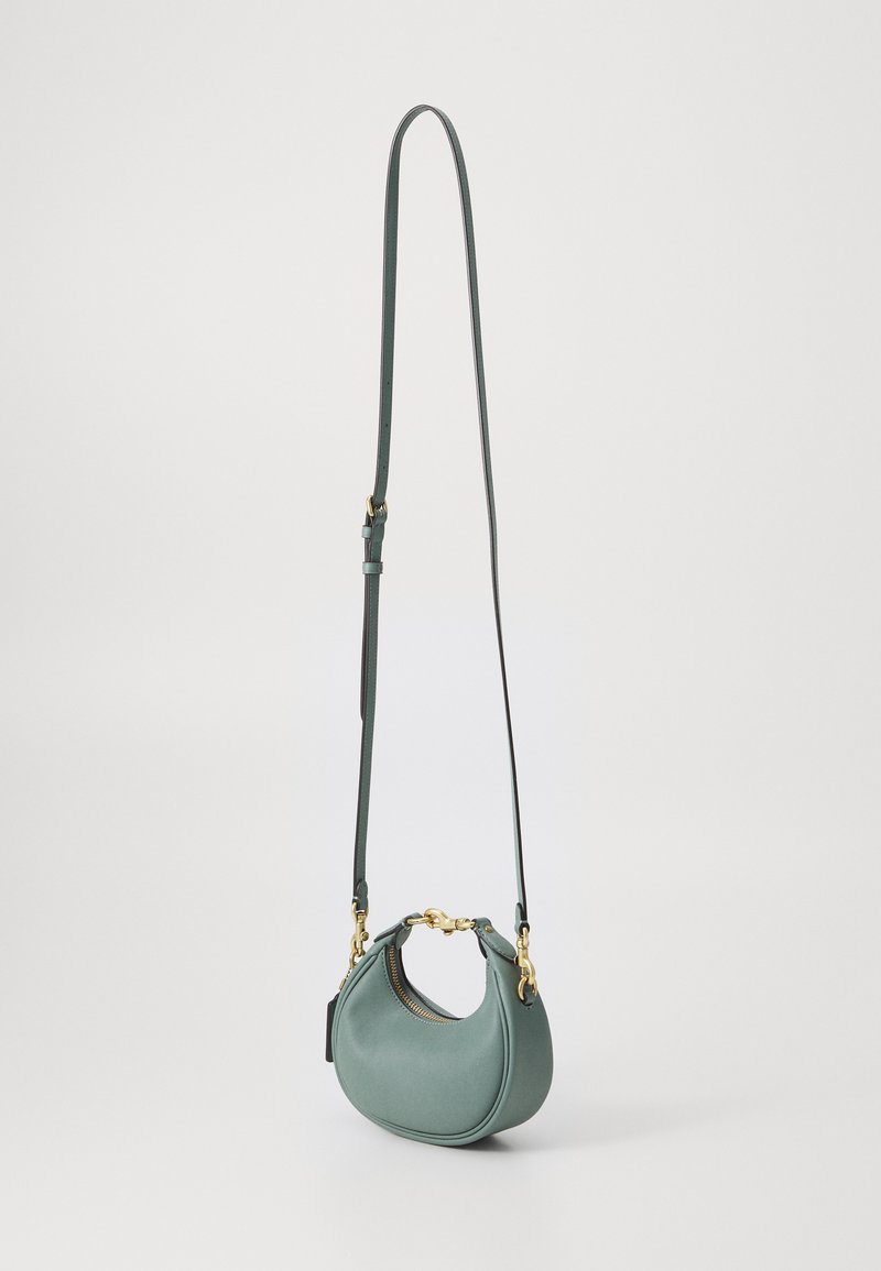 Bolso de mano de piel verde con forma redondeada, acentos en hardware dorado y una correa larga ajustable. Textura suave, diseño minimalista, cierre de cremallera.