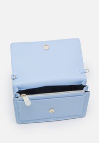 Portafoglio in pelle azzurro chiaro con superficie texture, scomparto con zipper, chiusura a scatto magnetica e foderato in tessuto nero con motivo logo.