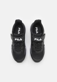 Baskets noires de sport avec une tige en mesh, un col rembourré, une sangle ajustable, des lacets et des accents blancs sur la semelle et le logo.