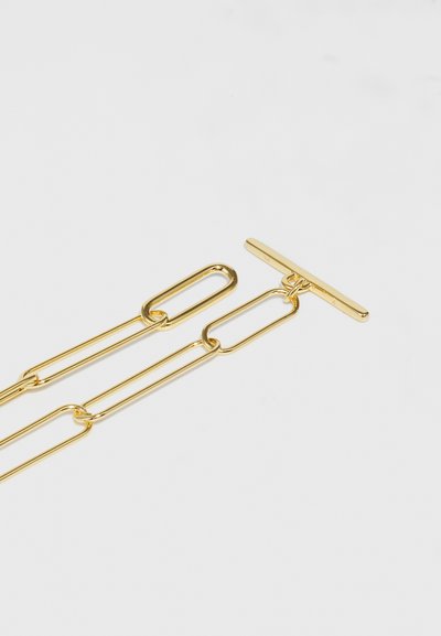 Guld metal kædehalskæde med forlængede led og T-bar lås. Glat overflade med en skinnende finish.