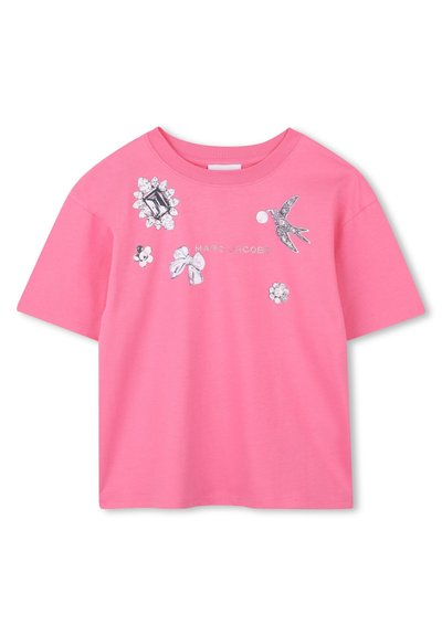 Rosa bomulls t-shirt med grafiska utsmyckningar som inkluderar blommor, rosetter och en fågel. Korta ärmar och en rund halsringning.