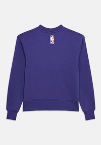 Sudadera morada con cuello redondo, puños ribeteados y una etiqueta con el logo de la NBA en la parte trasera del cuello. Tela suave y texturizada.