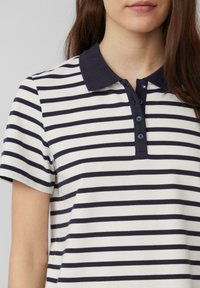 Navy en witte gestreepte polo met een knoopsluiting in de kraag, korte mouwen, van katoen, voorzien van vijf knopen en een lichte glans in de textuur.