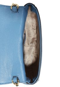 Modrá kožená kabelka s texturovaným povrchem a zlatými doplňky. Interiér má béžovou podšívku s jemným vzorem a jedno oddělení.