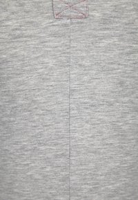 Tela de algodón gris con una textura suave, que presenta una costura central y un detalle de costura rosa en la parte superior. Diseño simple, sin patrones ni acentos.