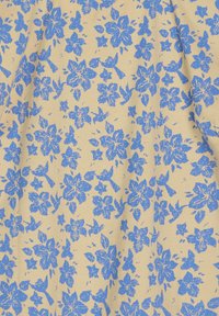 Tessuto beige chiaro con un denso motivo floreale blu. La texture appare liscia, morbida e leggermente opaca.
