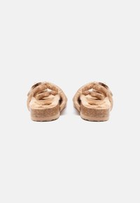 Tökéletes kényelmet és laza megjelenést biztosító, bézs színű, műszőrme béléssel ellátott slip-on szandálok, parafa talppal és két pánttal.