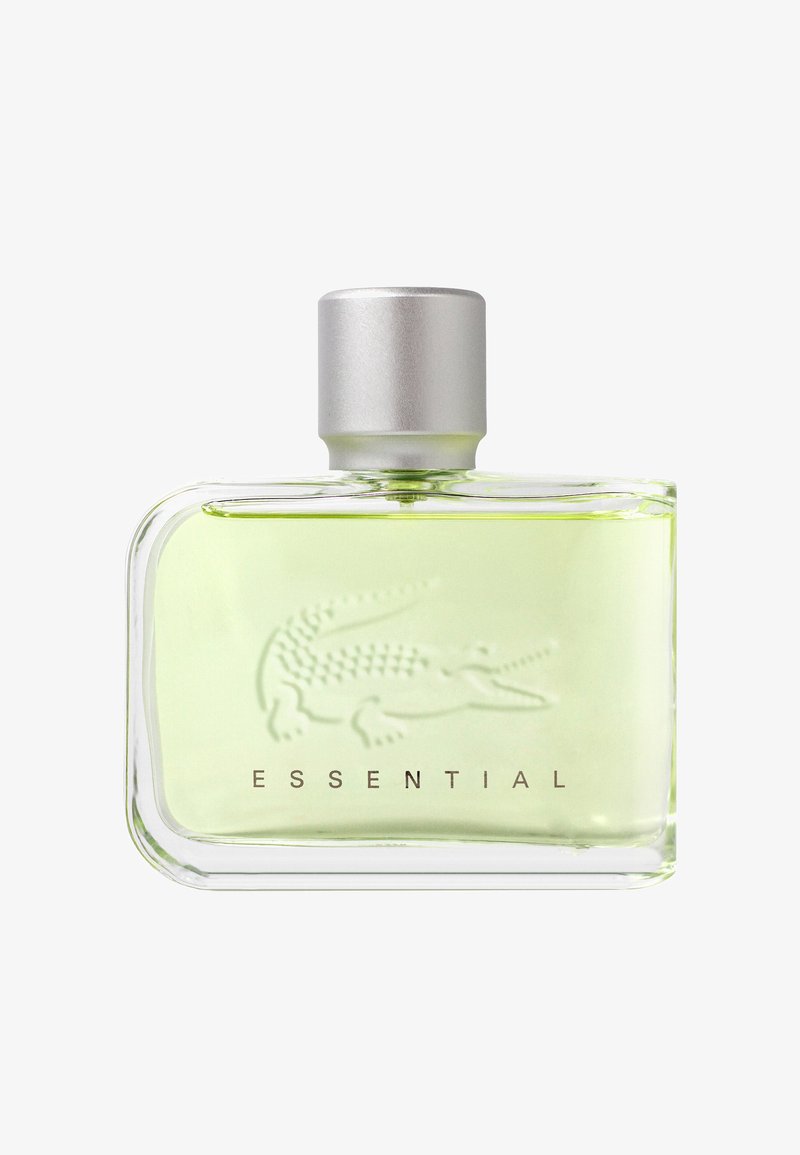 Przezroczysta prostokątna szklana butelka perfum z jasnozielonym płynem, srebrną zakrętką, wytłoczonym logo krokodyla oraz napisem "ESSENTIAL" poniżej.