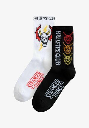 Czarno-białe bawełniane skarpetki za kostkę z wzorami czaszek i demonów, z nadrukiem "Stranger Things" i "Hellfire Club" w kontrastujących kolorach.