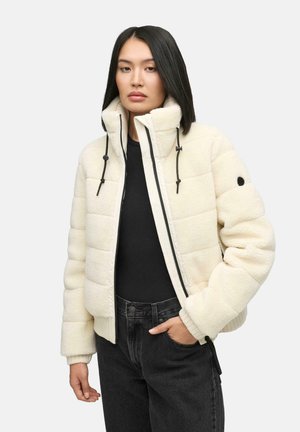 White fleece puffer jacket with a high collar, adjustable drawstrings, ribbed cuffs, and zip closure, paired with black jeans.