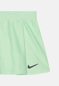 Falda atlética en verde menta con un diseño plisado, hecha de tela ligera. Presenta el logotipo de Nike en negro cerca del dobladillo.