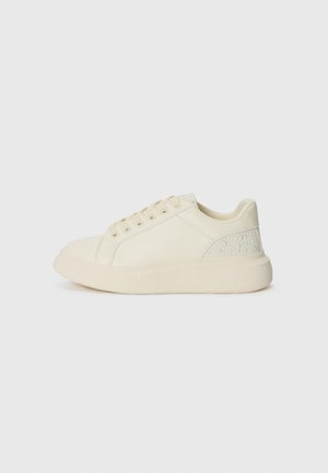 Sneakers bej deschis din piele netedă, cu un accent texturat pe toc care se potrivește, șase gauri pentru șireturi și o talpă groasă din cauciuc.
