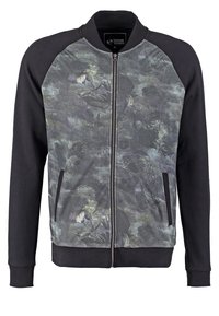 Sudadera con cremallera en negro y gris, con un estampado floral en la parte delantera, que presenta puños acanalados, un cuello alzado y bolsillos laterales.