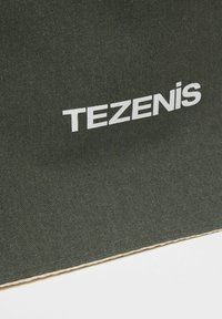 Tmavě zelená textilní taška se bílým logem "TEZENIS", s texturovaným povrchem a čistým detailem prošití.