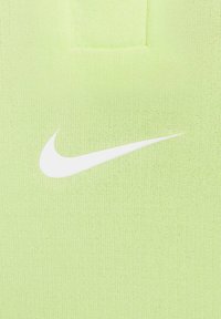 Lichtgroene Nike polo shirt met een textuurstof, korte kraag en een prominente witte swoosh-logo op de linkerkant van de borst.