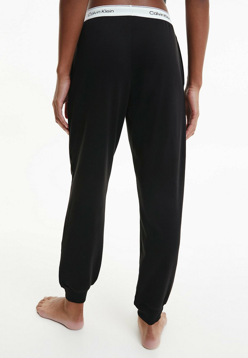 Schwarze Loungehosen mit elastischen Bündchen und einem elastischen Bund. Calvin Klein-Logo am Bund. Weicher Stoff mit lockerer Passform.