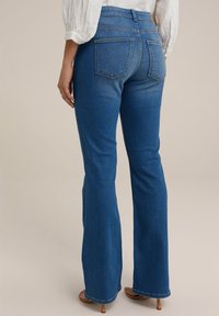 Sininen farkkukankainen leveälahkeinen housu korkealla vyötäröllä, kahdella takataskulla ja siistillä helmallaan. Sileä pinta, muotoilu lantion kohdalla, levenee polvien kohdalta.