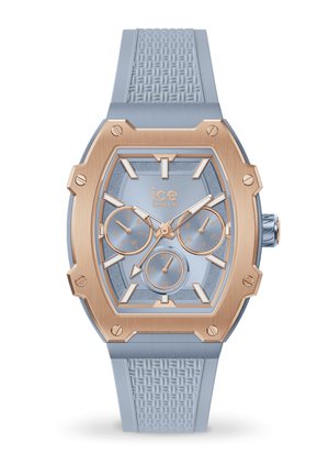 Blaues Silikonarmband mit geometrischem Ziffernblatt, roségoldenen Akzenten und drei Zusatzanzeigen. Texturiertes Armband und klare Zeitmarker sind vorhanden.