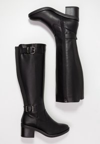 Czarne kozakowe buty do kolan na blokowym obcasie, z bocznymi zamkami błyskawicznymi oraz regulowanymi klamrami w okolicy łydki i kostki, leżące płasko na białej powierzchni.