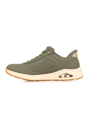 Oliijfgroene sportschoen met beige zool, geperforeerd zijpaneel, zichtbare luchtkussen in de hiel en vetersluiting.