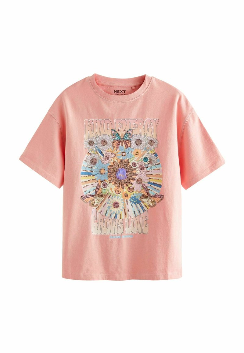 Camiseta de algodón rosa con mangas cortas. Presenta un gráfico grande de flores y mariposas con el texto "La energía amable hace crecer el amor" en negrita.