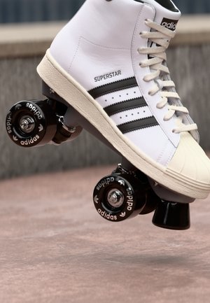 White high-top roller skate with a textured leather upper, black stripes, black wheels, and silver hardware. Features classic Adidas branding.