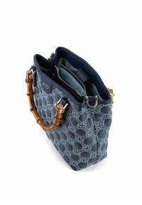 Sac à main bleu marine avec un extérieur texturé et à motifs. Équipé de poignées en bambou et d'un intérieur comprenant deux compartiments et une poche zippée.