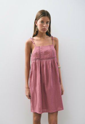 Vestido de algodón en rosa empolvado, con tirantes ajustables y tejido texturizado con detalles de costura debajo del busto.