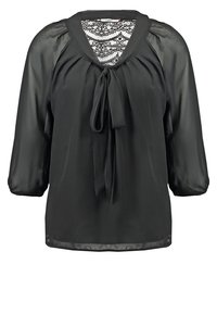 Zwarte satijnen blouse met een V-hals, kantdetail op de rug, strikdetail bij de halslijn en driekwartmouwen. Soepele textuur.