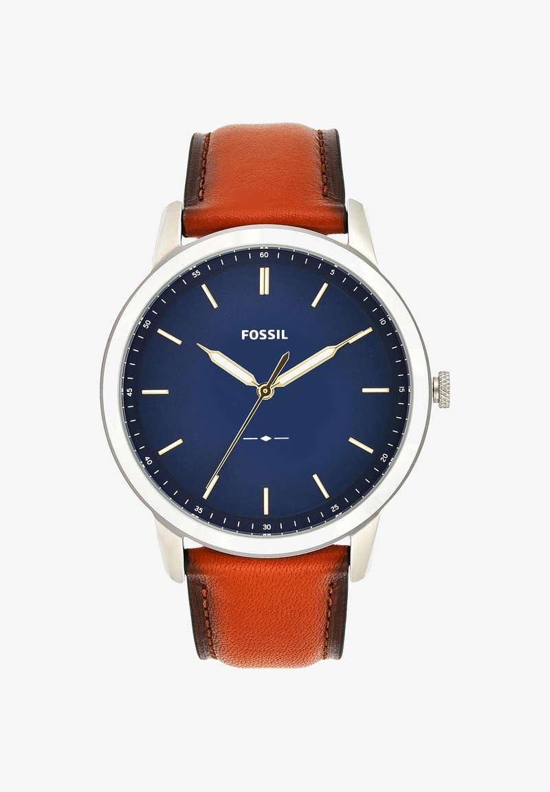 Montre Fossil ronde en argent avec cadran bleu, index et aiguilles dorés, et bracelet en cuir marron. L'heure indiquée est 10:10:35.